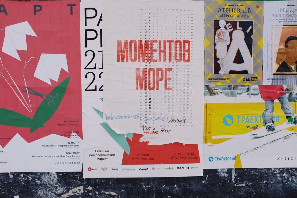 Colorful advertising posters on grunge old wall as creative and abstract background